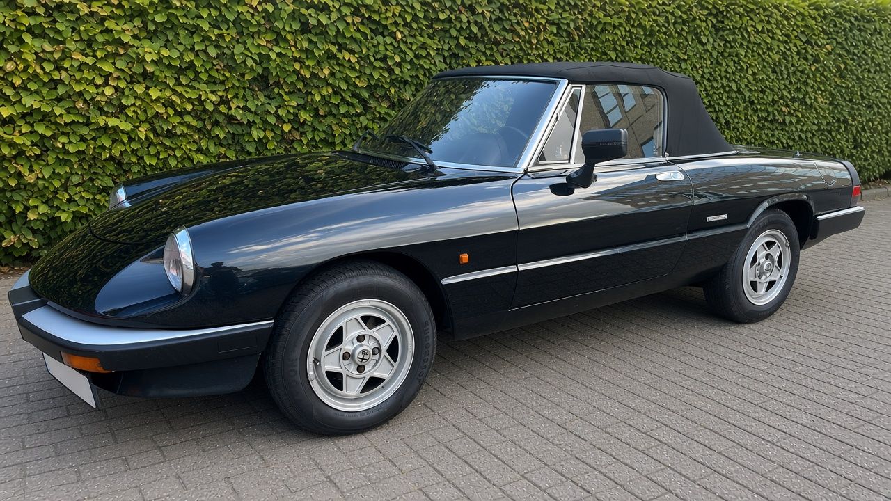Zwarte Alfa Romeo Spider cabriolet met zwarte softtop